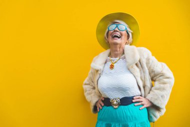 Mutlu ve oyuncu son sınıf kadını eğleniyor - 70 yaşından büyük güzel bir kadının portresi, şık kıyafetler, son sınıflar hakkında kavramlar