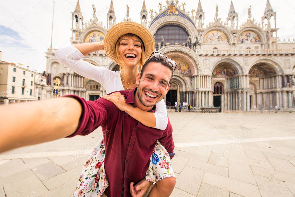 Beatiful young couple having fun while visiting Venice - Tourists travelling in Italy and sightseeing the most relevant landmarks of Venezia - Concepts about lifestyle, travel, tourism