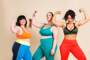 Group of 3 oversize women posing in studio - Beautiful girls accepting body imperfection, beauty shots in studio - Concepts about body acceptance, body positivity and diversity clipart