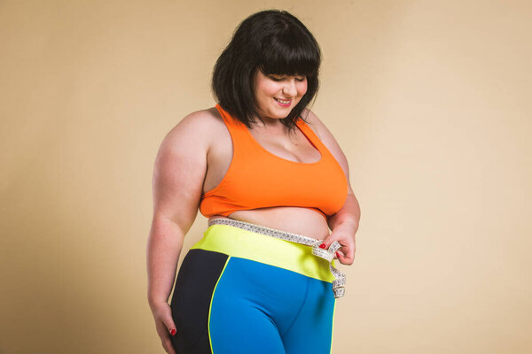 Pretty oversize woman wearing sportswear posing in studio - Beautiful girl accepting body imperfection, beauty shots in studio - Concepts about body acceptance, body positivity and diversity