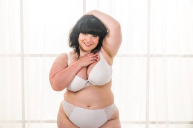 Stüdyoda poz veren iri yarı bir kadın, vücudunun kusurlarını kabul eden güzel bir kız, stüdyoda güzel bir poz, vücut kabulü, pozitiflik ve çeşitlilikle ilgili kavramlar.