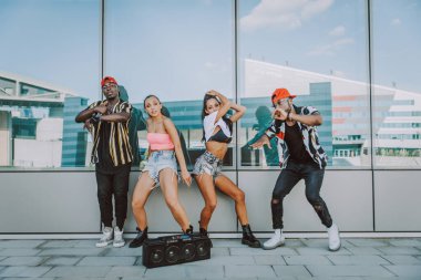 Hip hop ekibi dans ediyor, çok ırklı bir grup insan dışarıda eğleniyor.