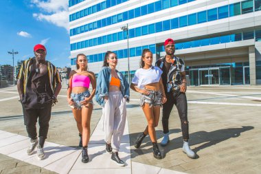 Hip hop ekibi dans ediyor, çok ırklı bir grup insan dışarıda eğleniyor.