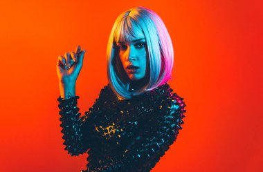 Gri peruklu genç kadın dans ediyor ve kutluyor. Renkli jel portreleri