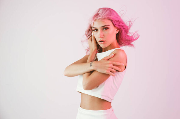 Young woman with pink hair dancing and having fun. Colored gel portraits with futuristic outfit
