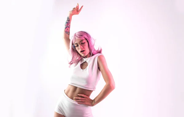 ピンクの髪のダンスと楽しさを持つ若い女性 未来的な衣装とカラーゲル肖像画 — ストック写真