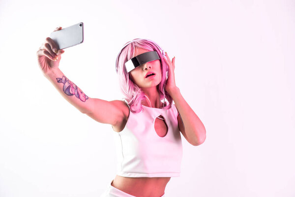 Young woman with pink hair dancing and having fun. Colored gel portraits with futuristic outfit