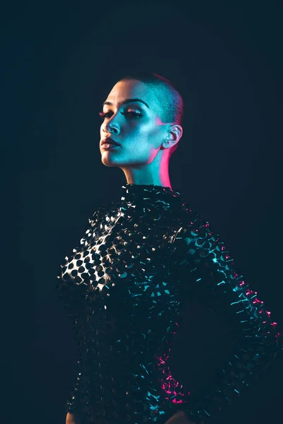 Modern beauty portrait. Young woman with shaved head. Colored gel fashion look
