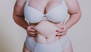 Vücut kabulü konsepti. Stüdyoda toplumsal önyargılara karşı poz veren kıvrımlı kız