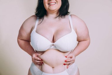 Vücut kabulü konsepti. Stüdyoda toplumsal önyargılara karşı poz veren kıvrımlı kız