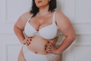 Vücut kabulü konsepti. Stüdyoda toplumsal önyargılara karşı poz veren kıvrımlı kız