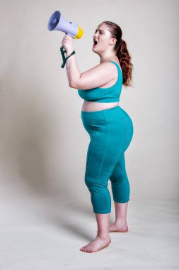 Ayrıca spor ve spor yapan cüsseli kadınlar. Mesajını iletmek için megafon kullanan bir kadın.