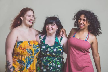 Artı parti yapan cüsseli kadınlar. Kıvrımlı çok ırklı kızlar elbise giyip eğleniyorlar.