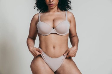 Vücut kabulü konsepti. Stüdyoda toplumsal önyargılara karşı poz veren kıvrımlı kız