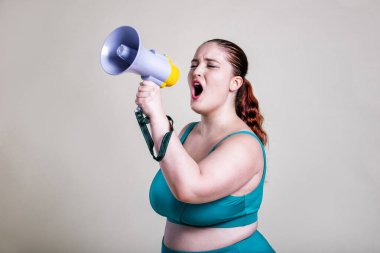 Ayrıca spor ve spor yapan cüsseli kadınlar. Mesajını iletmek için megafon kullanan bir kadın.