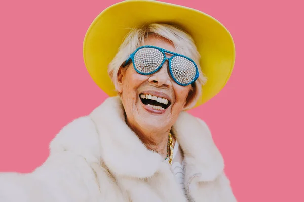 幸せな祖母の色の背景にポーズ 楽しさとお祝いの女性 — ストック写真