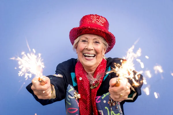 快乐的祖母在彩色背景上摆姿势 使用火花和庆祝的妇女 — 图库照片