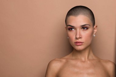 Stüdyoda poz veren çekici, kısa saçlı genç bir kadın.