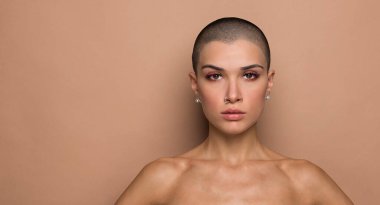 Stüdyoda poz veren çekici, kısa saçlı genç bir kadın.