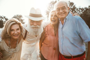 Bir grup son sınıf öğrencisi parkta piknik yapıyor ve eğleniyorlar.