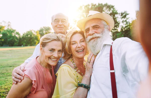 Grupa Seniorów Robi Piknik Parku Dobrze Się Bawi Robić Selfie — Zdjęcie stockowe