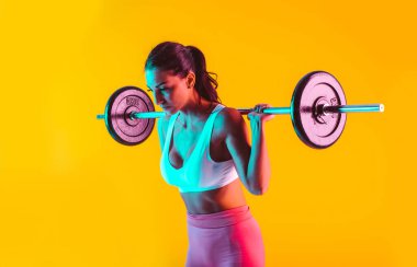 Spor salonunda halterli kadın eğitimi.