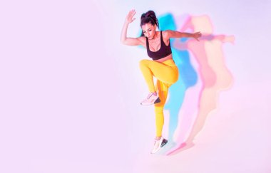 Güzel formda bir kadın spor yapıyor ve koşuyor. Stüdyo jeli ışıklandırma