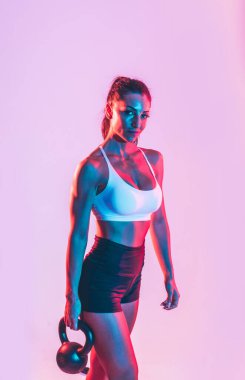 Spor salonunda halterli kadın eğitimi.