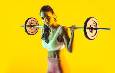 Spor salonunda halterli kadın eğitimi.