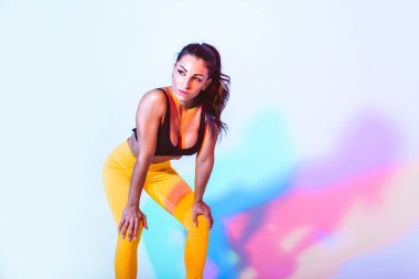 Güzel formda bir kadın spor yapıyor ve koşuyor. Stüdyo jeli ışıklandırma