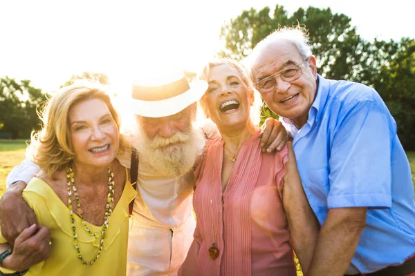 Grupa Młodych Seniorów Bawiących Się Świeżym Powietrzu Czterech Emerytów Łączących — Zdjęcie stockowe