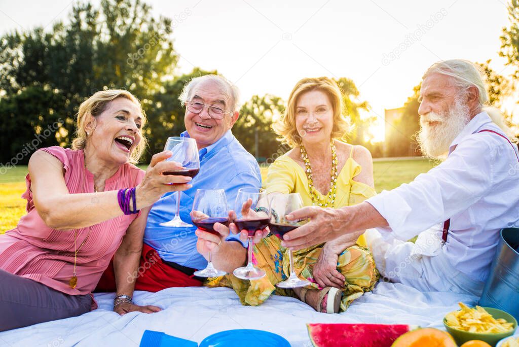 Group of youthful seniors having fun outdoors - Four pensioners bonding outdoors, concepts about lifestyle and elderly