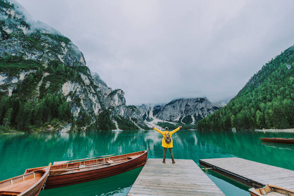 Traveler visiting an alpine lake at Braies, Italy - Tourist with hiking outfit having fun on vacation during autumn foliage - Concepts about travel, lifestyle and wanderlust