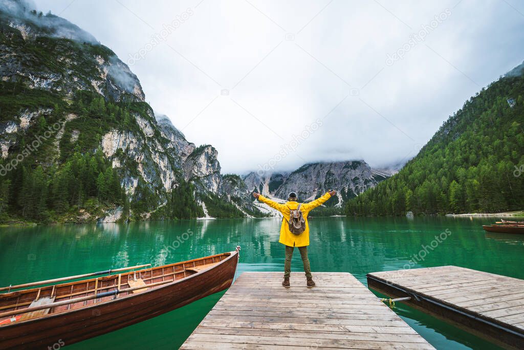 Traveler visiting an alpine lake at Braies, Italy - Tourist with hiking outfit having fun on vacation during autumn foliage - Concepts about travel, lifestyle and wanderlust
