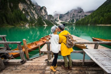 Braies, İtalya 'da bir dağ gölünü ziyaret eden genç ve güzel bir çift - sonbahar yaprakları arasında tatil yapan yürüyüş kıyafetli turistler - seyahat, yaşam tarzı ve seyahat tutkusu kavramları