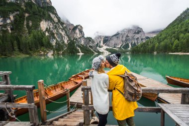 Braies, İtalya 'da bir dağ gölünü ziyaret eden genç ve güzel bir çift - sonbahar yaprakları arasında tatil yapan yürüyüş kıyafetli turistler - seyahat, yaşam tarzı ve seyahat tutkusu kavramları