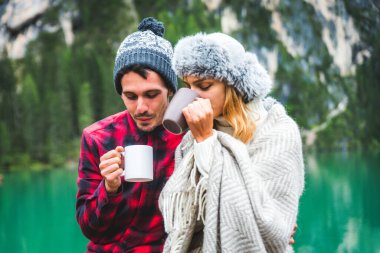 Braies, İtalya 'da bir dağ gölünü ziyaret eden genç ve güzel bir çift - sonbahar yaprakları arasında tatil yapan yürüyüş kıyafetli turistler - seyahat, yaşam tarzı ve seyahat tutkusu kavramları