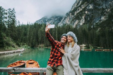 Braies, İtalya 'da bir dağ gölünü ziyaret eden genç ve güzel bir çift - sonbahar yaprakları arasında tatil yapan yürüyüş kıyafetli turistler - seyahat, yaşam tarzı ve seyahat tutkusu kavramları
