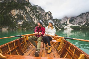 Braies, İtalya 'da bir dağ gölünü ziyaret eden genç ve güzel bir çift - sonbahar yaprakları arasında tatil yapan yürüyüş kıyafetli turistler - seyahat, yaşam tarzı ve seyahat tutkusu kavramları