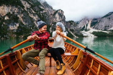 Braies, İtalya 'da bir dağ gölünü ziyaret eden genç ve güzel bir çift - sonbahar yaprakları arasında tatil yapan yürüyüş kıyafetli turistler - seyahat, yaşam tarzı ve seyahat tutkusu kavramları