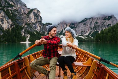 Braies, İtalya 'da bir dağ gölünü ziyaret eden genç ve güzel bir çift - sonbahar yaprakları arasında tatil yapan yürüyüş kıyafetli turistler - seyahat, yaşam tarzı ve seyahat tutkusu kavramları
