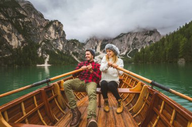 Braies, İtalya 'da bir dağ gölünü ziyaret eden genç ve güzel bir çift - sonbahar yaprakları arasında tatil yapan yürüyüş kıyafetli turistler - seyahat, yaşam tarzı ve seyahat tutkusu kavramları