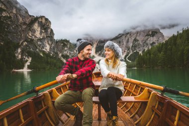 Braies, İtalya 'da bir dağ gölünü ziyaret eden genç ve güzel bir çift - sonbahar yaprakları arasında tatil yapan yürüyüş kıyafetli turistler - seyahat, yaşam tarzı ve seyahat tutkusu kavramları