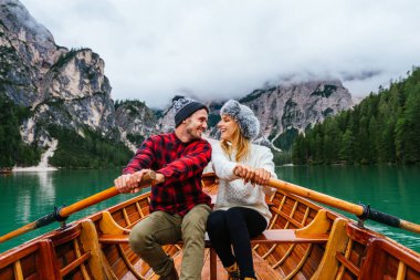 Braies, İtalya 'da bir dağ gölünü ziyaret eden genç ve güzel bir çift - sonbahar yaprakları arasında tatil yapan yürüyüş kıyafetli turistler - seyahat, yaşam tarzı ve seyahat tutkusu kavramları