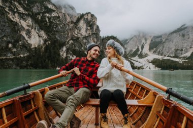 Braies, İtalya 'da bir dağ gölünü ziyaret eden genç ve güzel bir çift - sonbahar yaprakları arasında tatil yapan yürüyüş kıyafetli turistler - seyahat, yaşam tarzı ve seyahat tutkusu kavramları