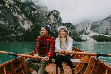 Braies, İtalya 'da bir dağ gölünü ziyaret eden genç ve güzel bir çift - sonbahar yaprakları arasında tatil yapan yürüyüş kıyafetli turistler - seyahat, yaşam tarzı ve seyahat tutkusu kavramları