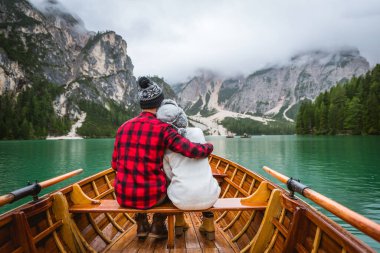 Braies, İtalya 'da bir dağ gölünü ziyaret eden genç ve güzel bir çift - sonbahar yaprakları arasında tatil yapan yürüyüş kıyafetli turistler - seyahat, yaşam tarzı ve seyahat tutkusu kavramları