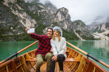Braies, İtalya 'da bir dağ gölünü ziyaret eden genç ve güzel bir çift - sonbahar yaprakları arasında tatil yapan yürüyüş kıyafetli turistler - seyahat, yaşam tarzı ve seyahat tutkusu kavramları