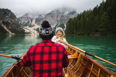 Braies, İtalya 'da bir dağ gölünü ziyaret eden genç ve güzel bir çift - sonbahar yaprakları arasında tatil yapan yürüyüş kıyafetli turistler - seyahat, yaşam tarzı ve seyahat tutkusu kavramları