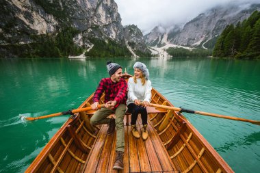 Braies, İtalya 'da bir dağ gölünü ziyaret eden genç ve güzel bir çift - sonbahar yaprakları arasında tatil yapan yürüyüş kıyafetli turistler - seyahat, yaşam tarzı ve seyahat tutkusu kavramları